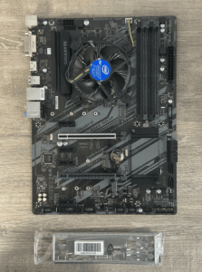 Gigabyte GA-B360 HD3P moederbord met CPU-koeler - bovenaanzicht en bijgeleverde I/O-schild