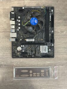 Asrock H510M-HDV/M.2 moederbord met geïnstalleerde CPU-koeler en bijgeleverde I/O-shield, bovenaanzicht